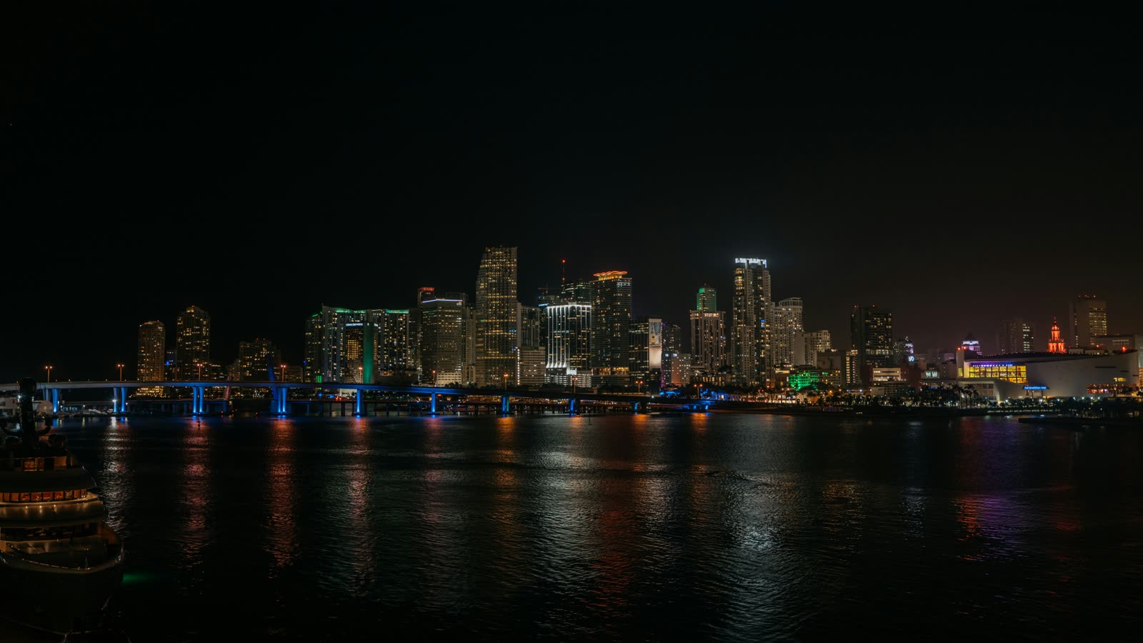 Downtown Miami skyline lit up at night, seen across Biscayne Bay